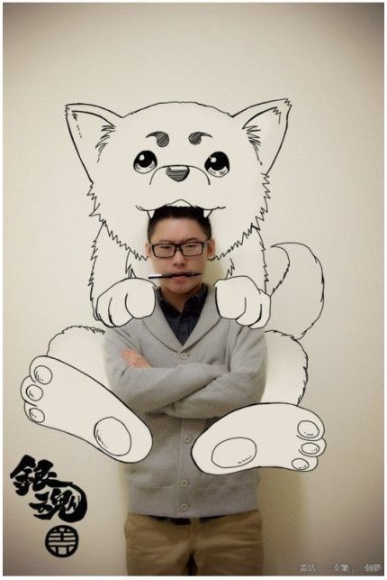 Азиатский парень рисует на стене аниме с помощью фотошопа