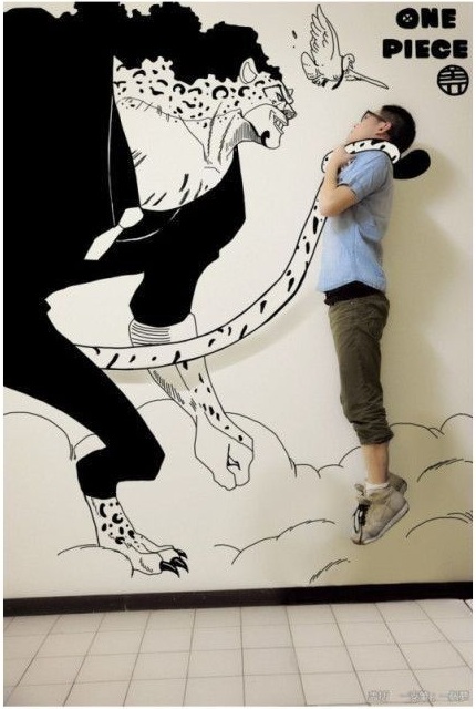 Азиатский парень рисует на стене аниме с помощью фотошопа