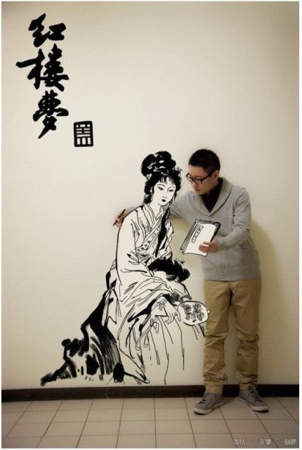 Азиатский парень рисует на стене аниме с помощью фотошопа