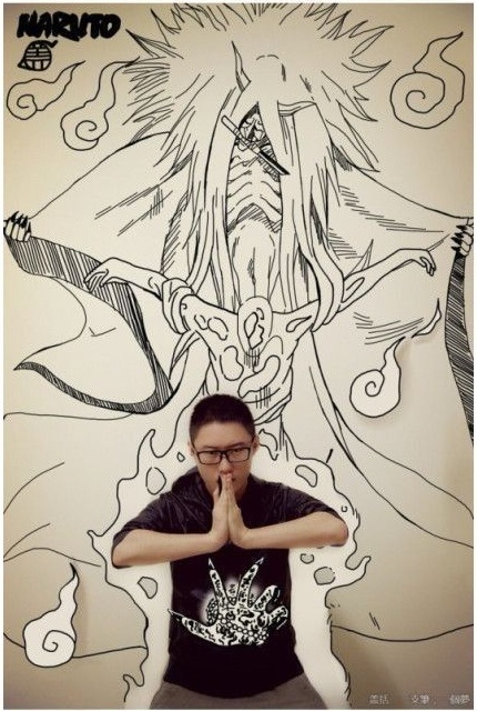 Азиатский парень рисует на стене аниме с помощью фотошопа