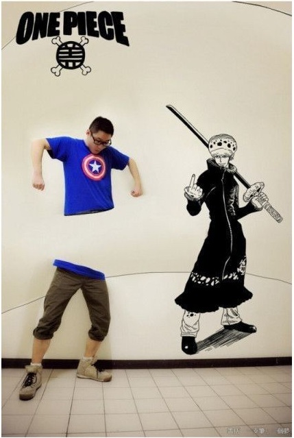 Азиатский парень рисует на стене аниме с помощью фотошопа