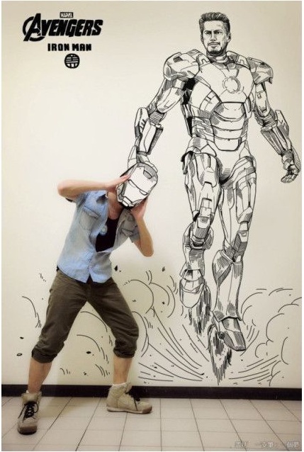 Азиатский парень рисует на стене аниме с помощью фотошопа