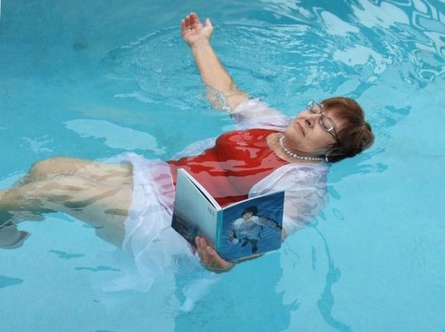 Странная женщина, фотографируется, в воде