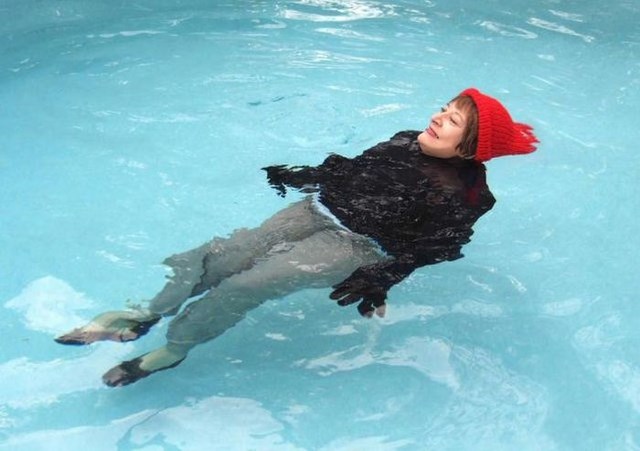 Странная женщина, фотографируется, в воде