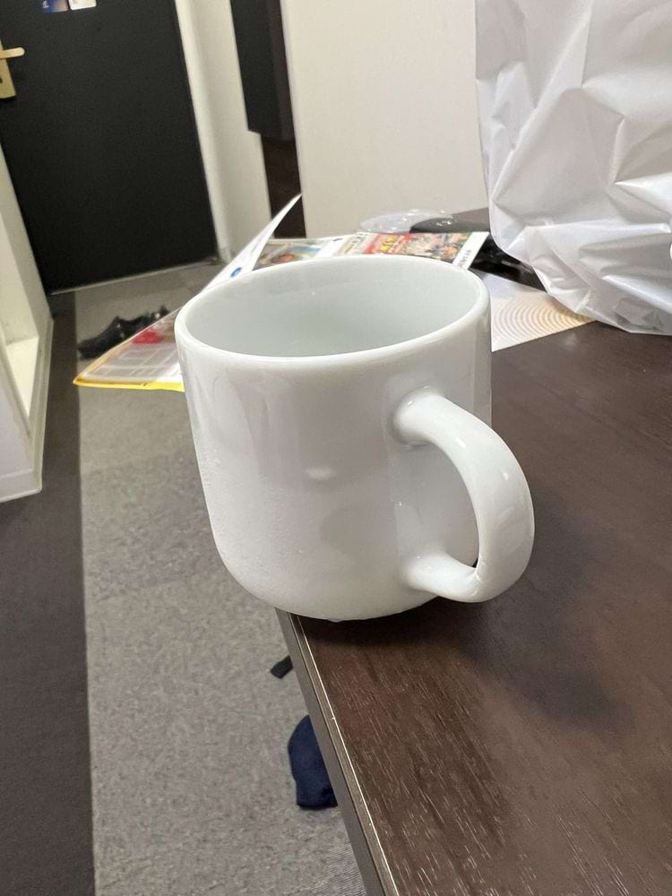 кружка стоит на краю стола