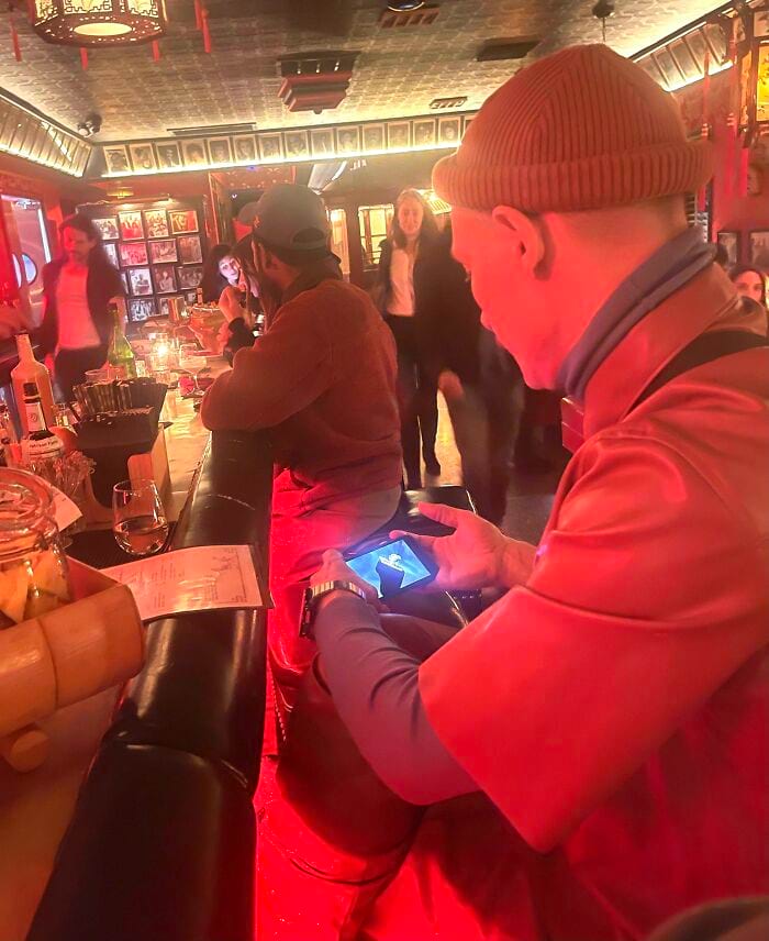 мужчина смотрит на телефон в баре