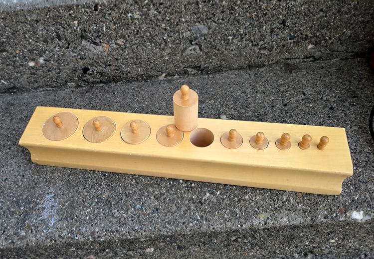  развивающая игрушка для маленьких детей, в которой ребёнок должен вставить колышки в подходящие отверстия