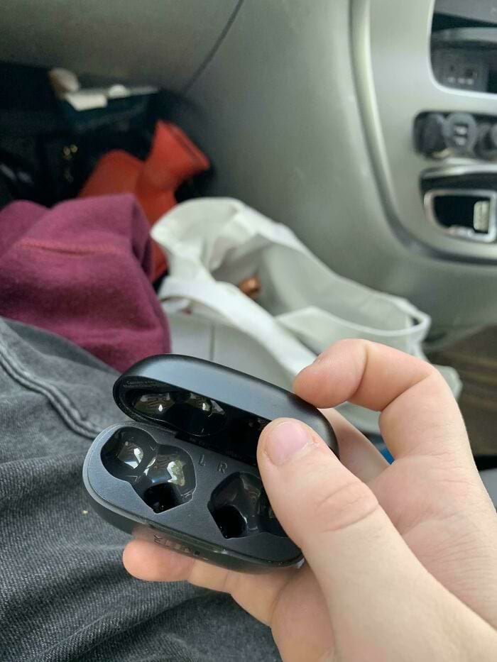 рука держит пустой кейс с наушниками