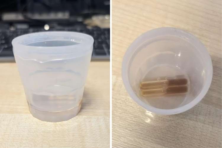 Большая пластиковая рюмка, в основании которой вставлены две капсулы с коричневой жидкостью