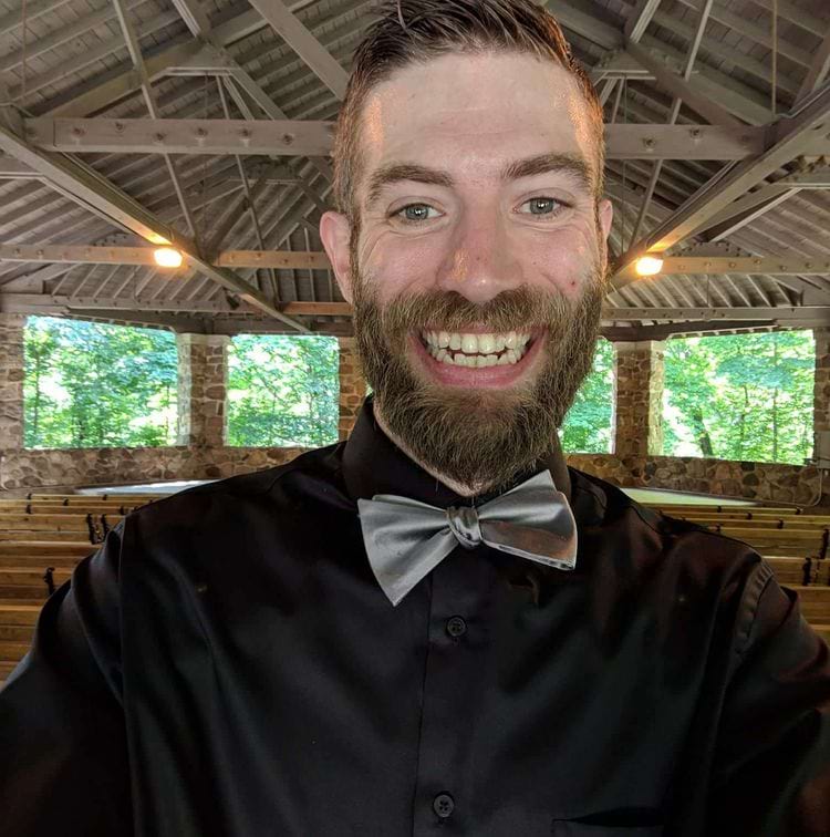 мужчина с бородой улыбается в камеру