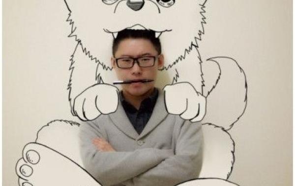 Азиатский парень рисует на стене аниме с помощью фотошопа