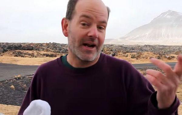 пить воду в Исландии, ветра в Исландии, сила ветра в Исландии, мужчина пытается пить воду в Исландии